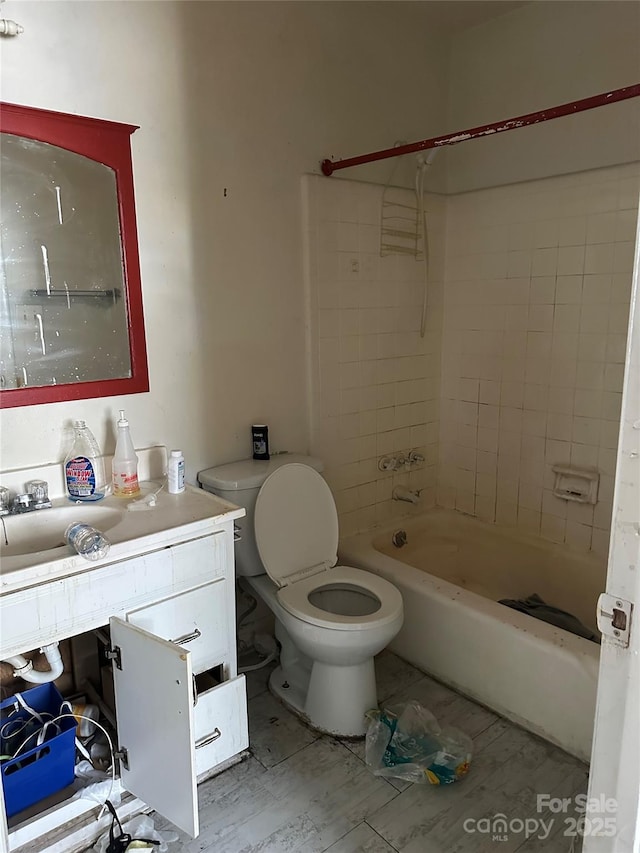 full bathroom featuring vanity, toilet, and tiled shower / bath