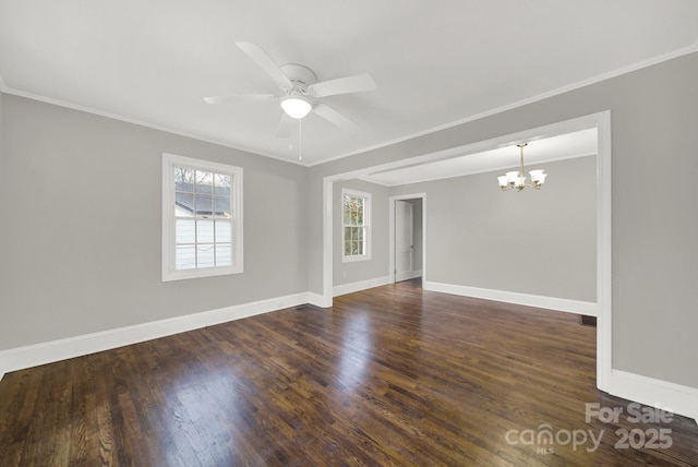 spare room featuring ornamental molding, ceiling fan with notable chandelier, plenty of natural light, and dark wood-type flooring