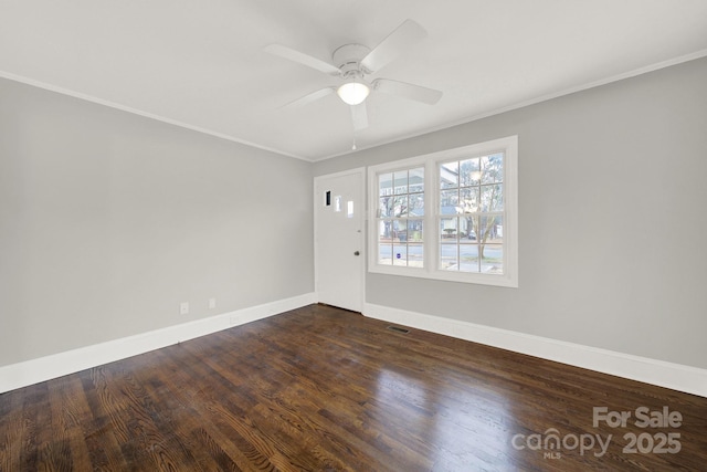 spare room featuring dark hardwood / wood-style flooring, ceiling fan, and ornamental molding