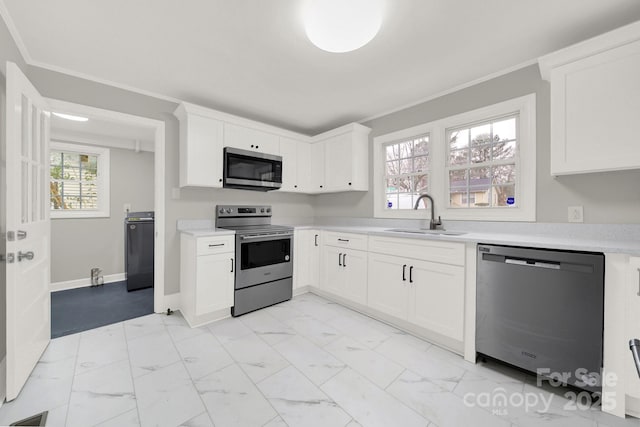 kitchen featuring crown molding, white cabinetry, sink, and stainless steel appliances