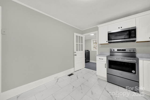 kitchen featuring white cabinets, appliances with stainless steel finishes, and crown molding