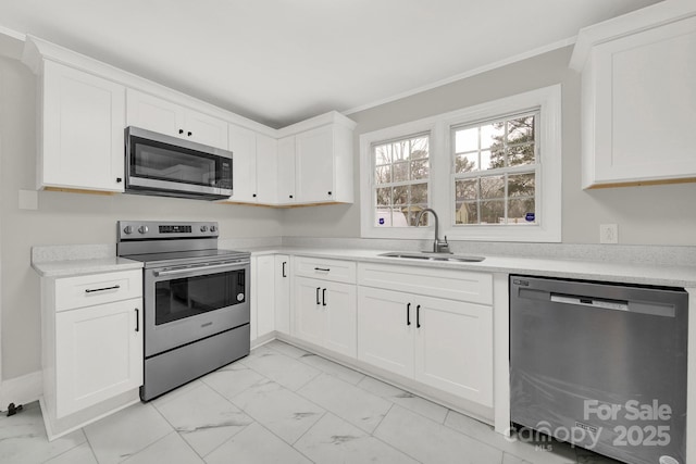 kitchen featuring appliances with stainless steel finishes, white cabinetry, ornamental molding, and sink