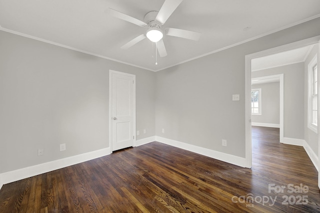 empty room featuring ceiling fan, crown molding, and dark wood-type flooring