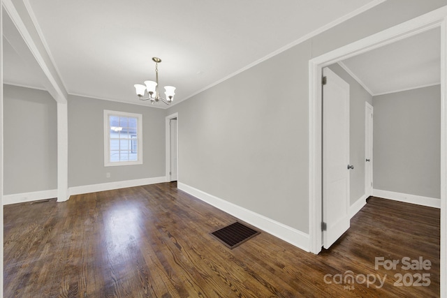 spare room with a chandelier, dark wood-type flooring, and ornamental molding