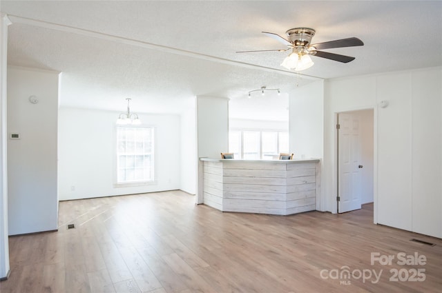 unfurnished room featuring a textured ceiling, light hardwood / wood-style flooring, and a wealth of natural light