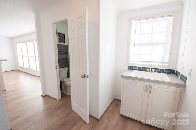 bathroom featuring hardwood / wood-style floors, a healthy amount of sunlight, and toilet