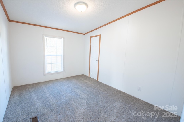 carpeted spare room featuring crown molding and a textured ceiling