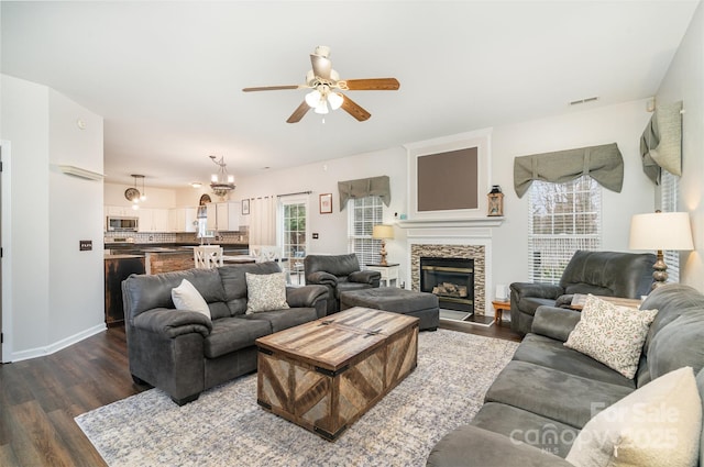 living room with a fireplace, dark hardwood / wood-style flooring, and ceiling fan