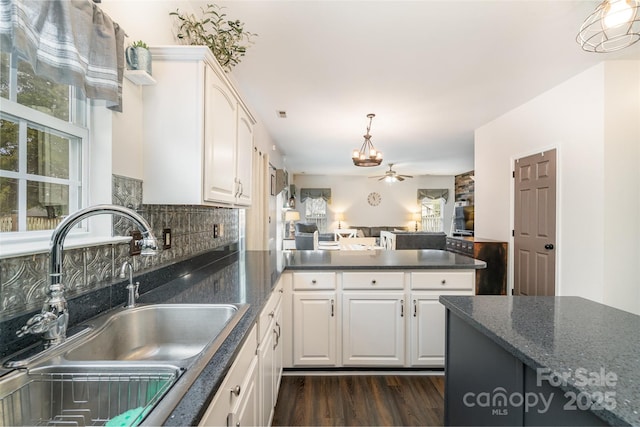 kitchen with ceiling fan, dark wood-type flooring, sink, white cabinetry, and hanging light fixtures