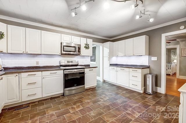 kitchen with white cabinets, backsplash, stainless steel appliances, and ornamental molding