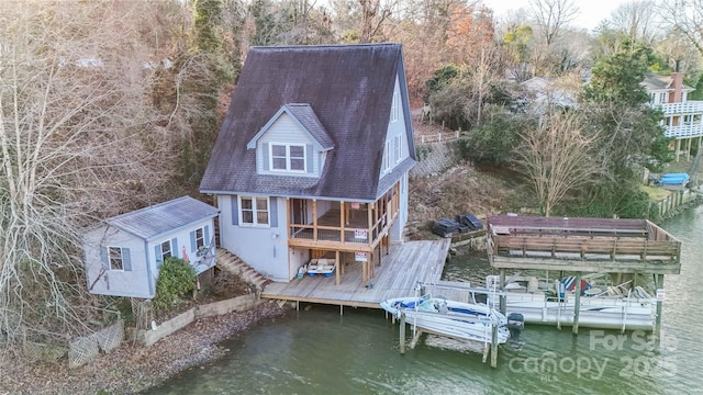 rear view of house with an outbuilding and a deck with water view