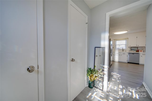 hallway with sink and light hardwood / wood-style flooring