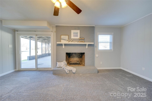 unfurnished living room with carpet flooring, ceiling fan, a fireplace, and ornamental molding