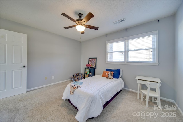 carpeted bedroom with a textured ceiling and ceiling fan