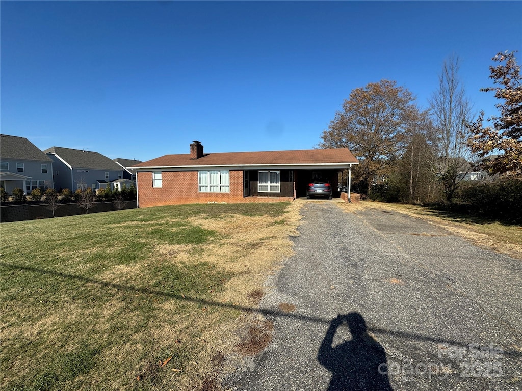 view of front of property with a front lawn and a carport