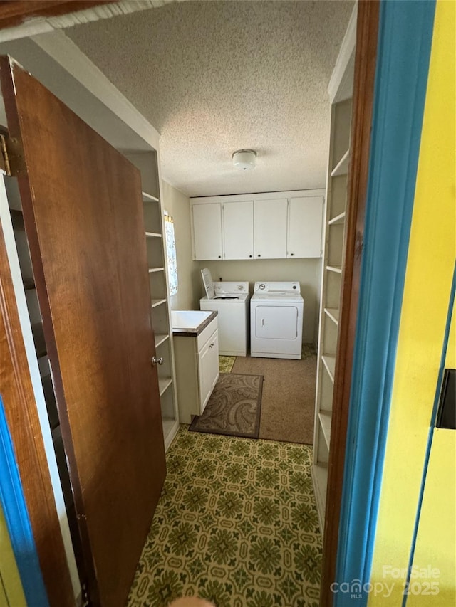 washroom featuring cabinets, a textured ceiling, and independent washer and dryer