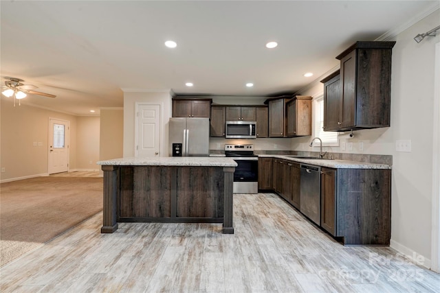 kitchen featuring dark brown cabinetry, ceiling fan, sink, a center island, and appliances with stainless steel finishes