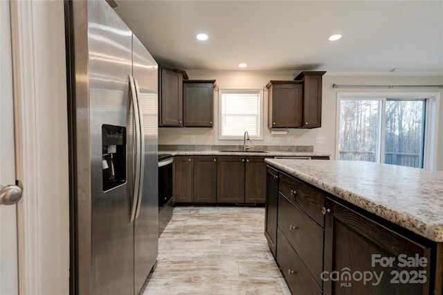 kitchen with plenty of natural light, dark brown cabinets, sink, and stainless steel refrigerator with ice dispenser