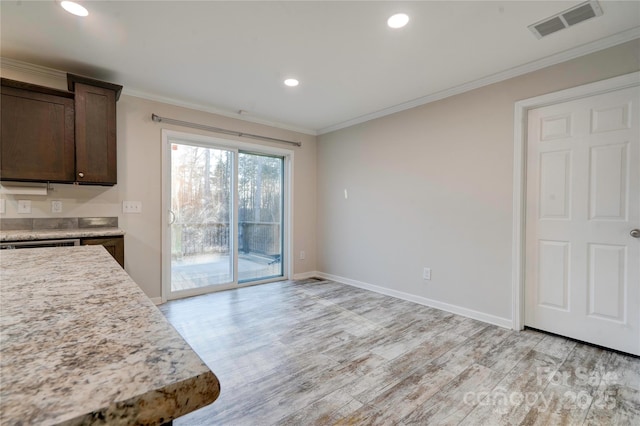 kitchen with light wood-type flooring, dark brown cabinetry, and crown molding