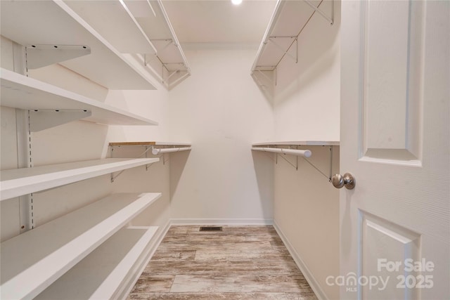 spacious closet featuring light hardwood / wood-style flooring