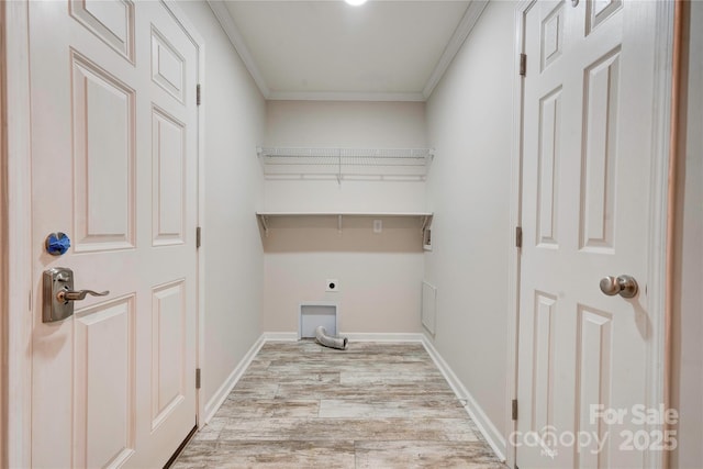 clothes washing area featuring hookup for an electric dryer, light hardwood / wood-style floors, and ornamental molding