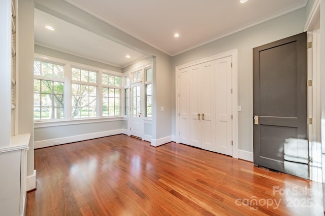 entrance foyer with wood-type flooring and crown molding