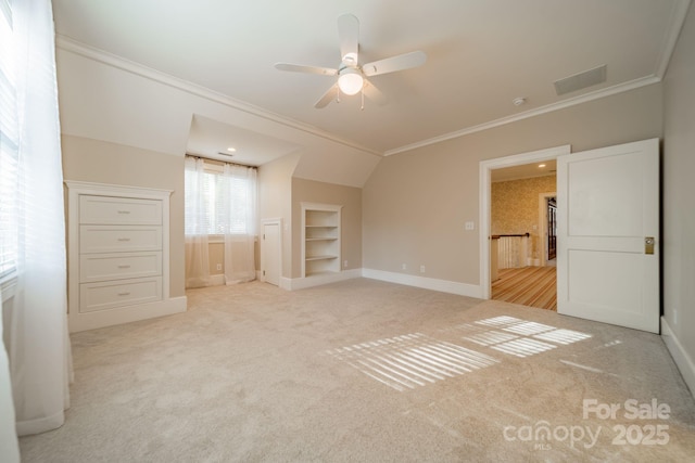 unfurnished bedroom with ceiling fan, a spacious closet, crown molding, light colored carpet, and vaulted ceiling