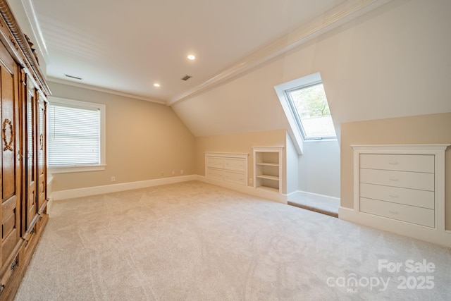 additional living space with built in shelves, light colored carpet, and lofted ceiling