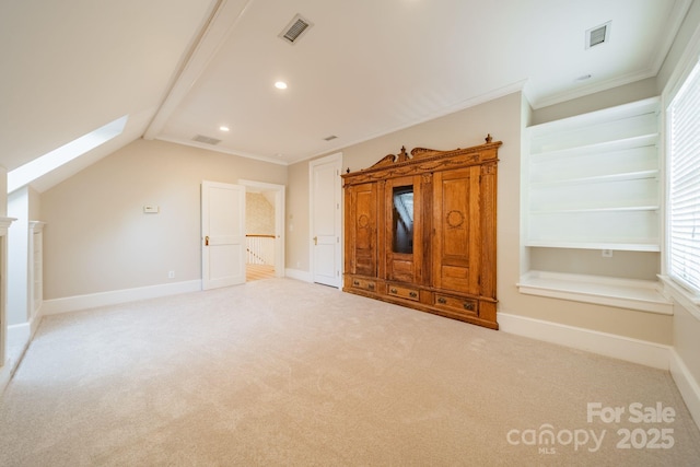 unfurnished bedroom with light colored carpet, ornamental molding, and vaulted ceiling with skylight