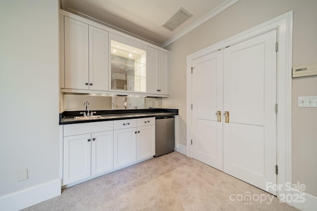 interior space with stainless steel dishwasher, light colored carpet, crown molding, sink, and white cabinets