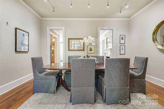 1333 Carlton Ave, Charlotte, NC 28203 - dining room featuring wood finished floors, rail lighting, crown molding, and baseboards