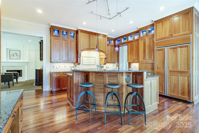1333 Carlton Ave, Charlotte, NC 28203 - kitchen featuring a kitchen island with sink, stone countertops, backsplash, and dark wood finished floors