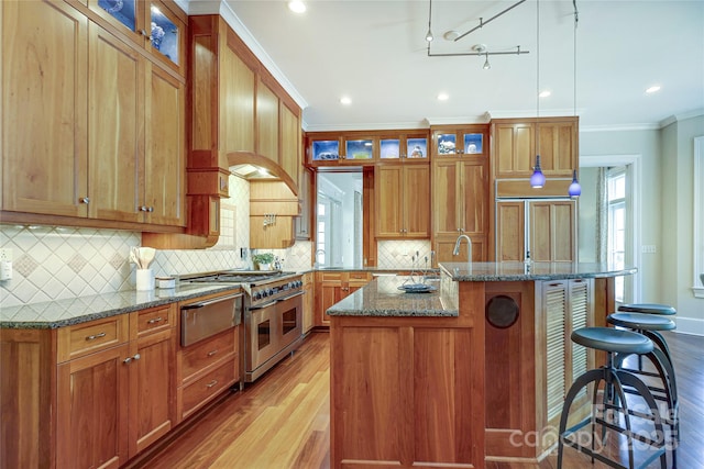 1333 Carlton Ave, Charlotte, NC 28203 - kitchen featuring range with two ovens, ornamental molding, light wood-style floors, and a kitchen island with sink