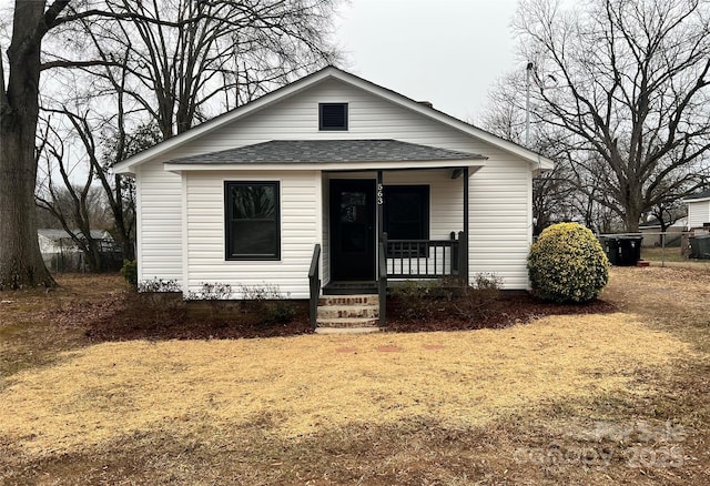 bungalow-style house with a front lawn and covered porch