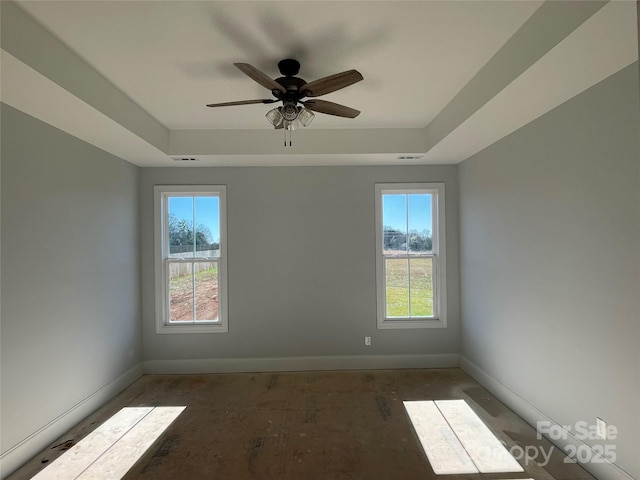 spare room with a raised ceiling and ceiling fan