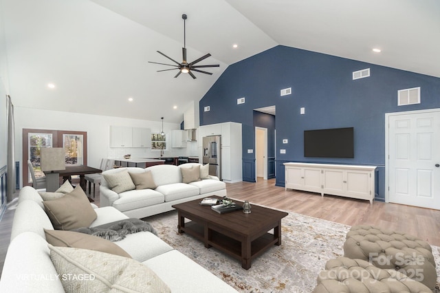 living room with light wood finished floors, visible vents, and a ceiling fan