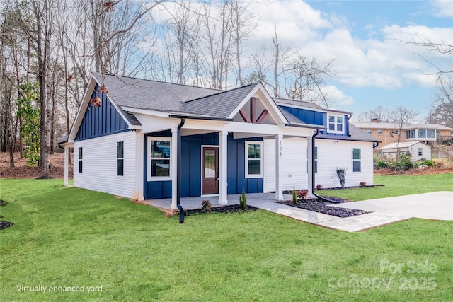 modern farmhouse with a porch, a shingled roof, board and batten siding, and a front yard