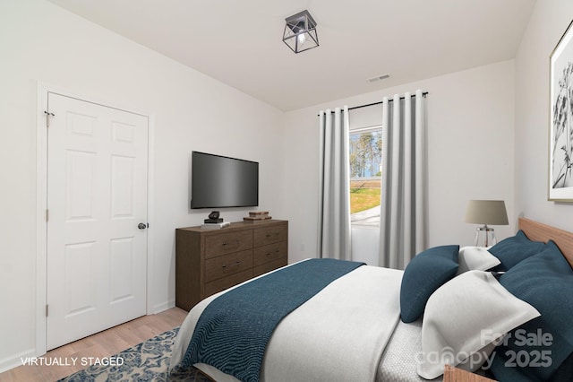 bedroom featuring light wood finished floors and visible vents