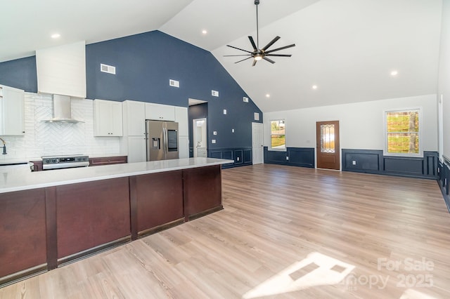 kitchen featuring stainless steel appliances, light countertops, visible vents, white cabinetry, and wall chimney exhaust hood