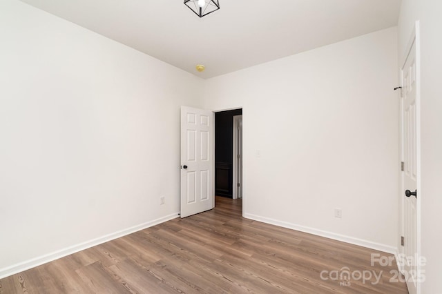 unfurnished room featuring baseboards and wood finished floors