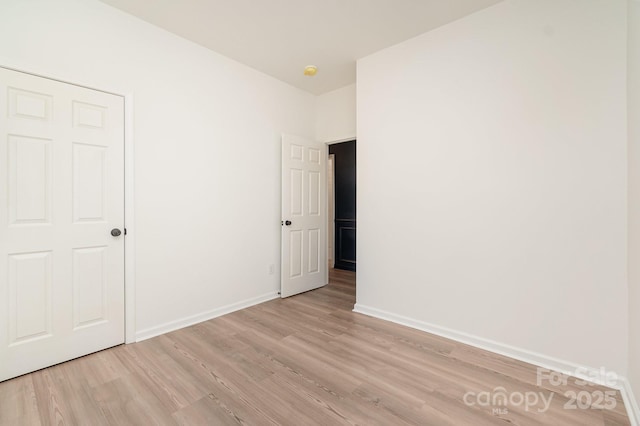 unfurnished bedroom featuring baseboards and light wood-style floors