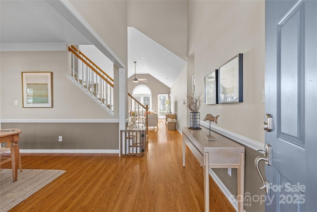 foyer with ceiling fan, ornamental molding, vaulted ceiling, and hardwood / wood-style flooring