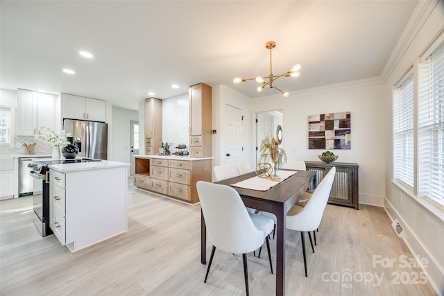 dining area with radiator heating unit, light hardwood / wood-style floors, an inviting chandelier, and ornamental molding