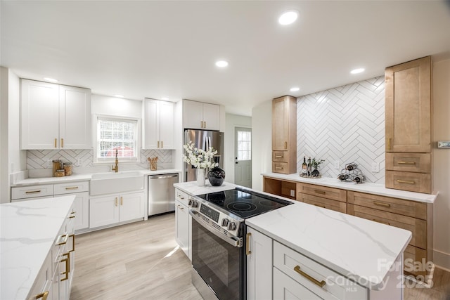 kitchen with backsplash, sink, white cabinets, and stainless steel appliances