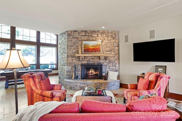 living room featuring a stone fireplace