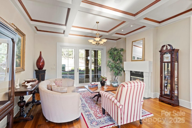 living room with wood-type flooring, beam ceiling, coffered ceiling, and a notable chandelier