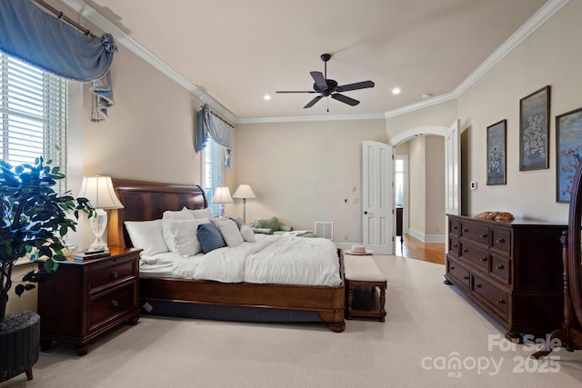 carpeted bedroom featuring ceiling fan and crown molding