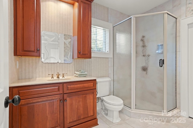 bathroom featuring tile patterned flooring, vanity, toilet, and an enclosed shower