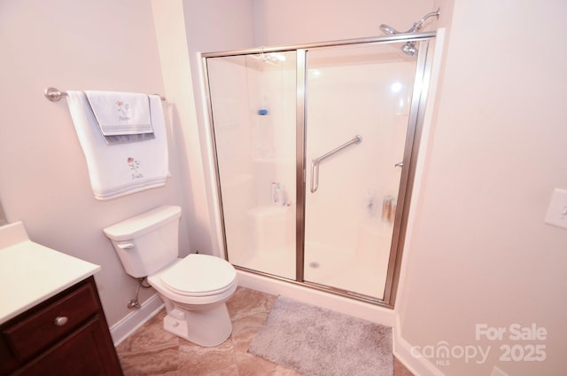 bathroom with vanity, toilet, and a shower with shower door