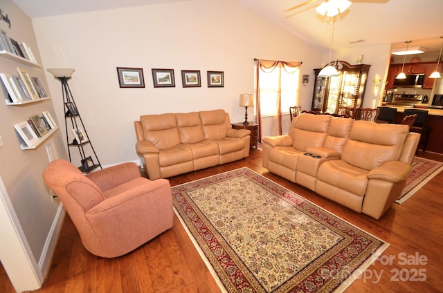 living room with ceiling fan, high vaulted ceiling, and wood-type flooring